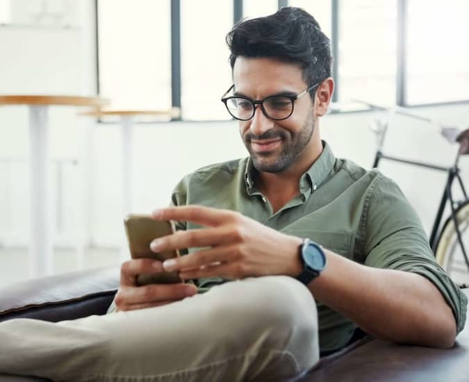 Man Sitting Down and Looking at His Phone