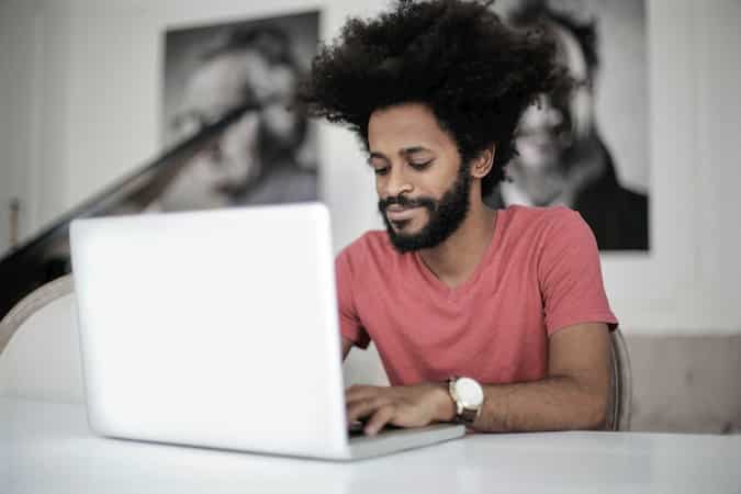 Man Researching Cloud-Based Solutions and Phone Systems on His Laptop